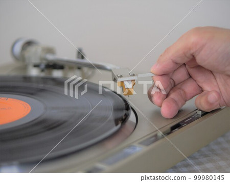 Daily life listening to music by dropping a needle on an analog record player Daily life listening to music by dropping a needle on an analog record player 99980145