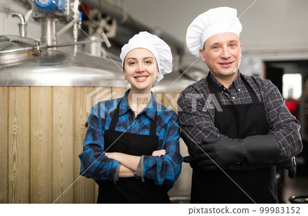 Portrait of man and woman brewmasters in beer factory Portrait of man and woman brewmasters in beer factory 99983152