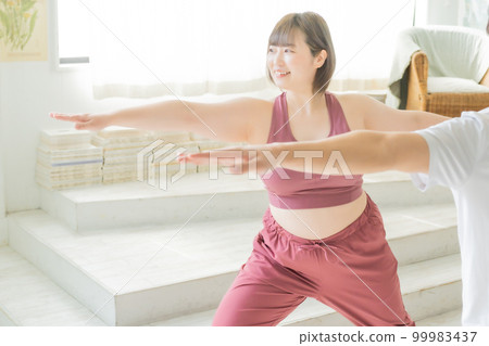 Woman exercising at home and her boyfriend supporting her Woman exercising at home and her boyfriend supporting her 99983437