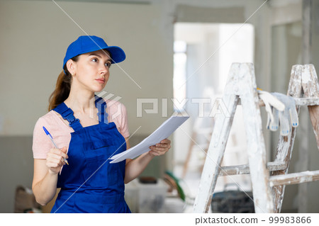 Woman architect checking plan of renovating apartment 99983866