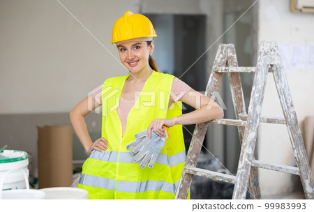Woman worker posing in apartment being renovated 99983993