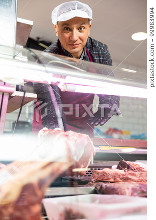 Professional butcher showing piece of fresh raw veal tenderloin 99983994