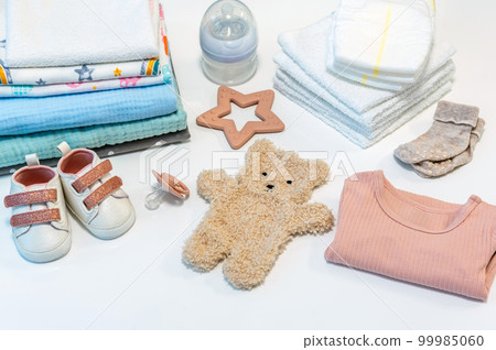 Concept of giving birth. Set of clothes and accessories for newborn on white background Concept of giving birth. Set of clothes and accessories for newborn on white background 99985060