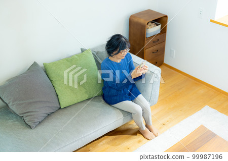 Senior smartphone in the living room 99987196