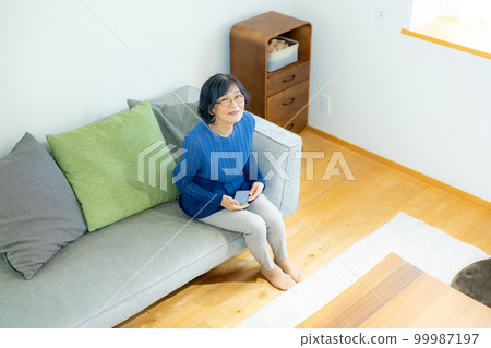 Senior smartphone in the living room 99987197