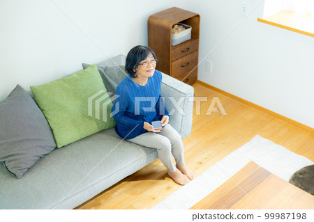 Senior smartphone in the living room 99987198