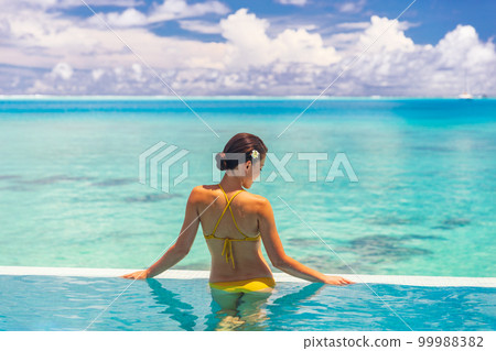 Wellness spa healthy body care woman relaxing in infinity swimming pool at luxury resort pampering summer getaway vacation travel background lifestyle Wellness spa healthy body care woman relaxing in infinity swimming pool at luxury resort pampering summer getaway vacation travel background lifestyle 99988382