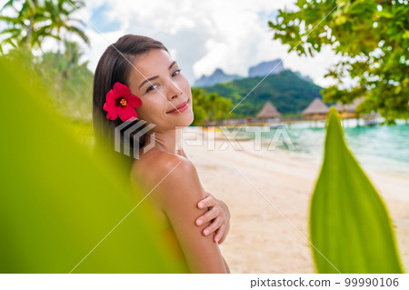Spa Asian natural beauty woman wellness skin care, body and face care looking at camera serene outside at pardise beach on Bora Bora. Beautiful skincare concept with mixed race model girl Spa Asian natural beauty woman wellness skin care, body and face care looking at camera serene outside at pardise beach on Bora Bora. Beautiful skincare concept with mixed race model girl 99990106