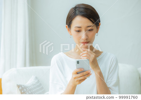 Woman in the living room Smartphone 99991760