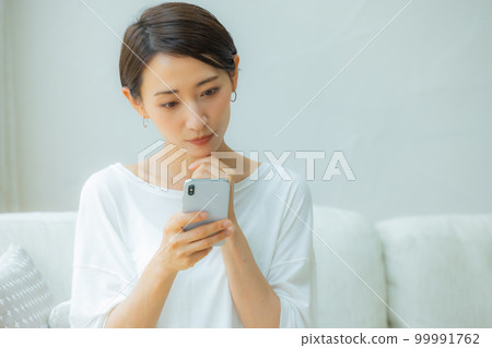 在客廳智能手機的女人 在客廳智能手機的女人 99991762