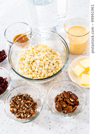 Measured ingredients in glass mixing bowls to make white chocolate cranberry pecan fudge. Measured ingredients in glass mixing bowls to make white chocolate cranberry pecan fudge. 99991961