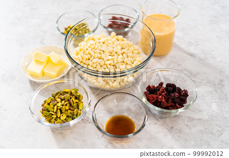 Measured ingredients in glass mixing bowls to prepare cranberry pistachio fudge. 99992012