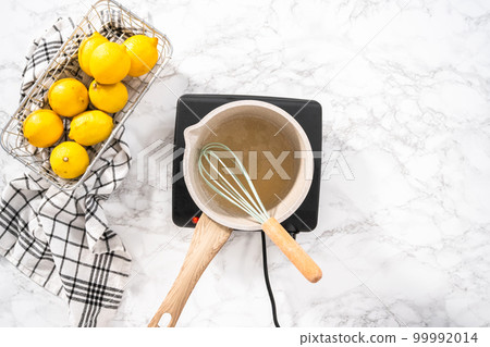 Cooking cake syrup for cake in a saucepan. Cooking cake syrup for cake in a saucepan. 99992014