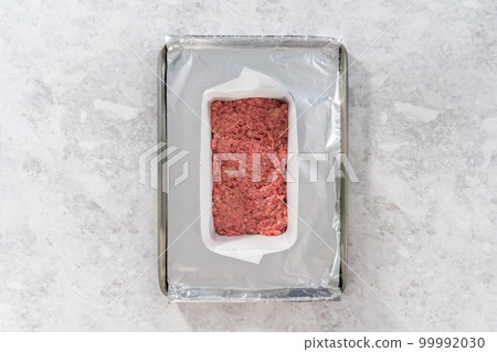 Flat lay. Preparing classic meatloaf in a loaf pan lined with parchment paper. Flat lay. Preparing classic meatloaf in a loaf pan lined with parchment paper. 99992030
