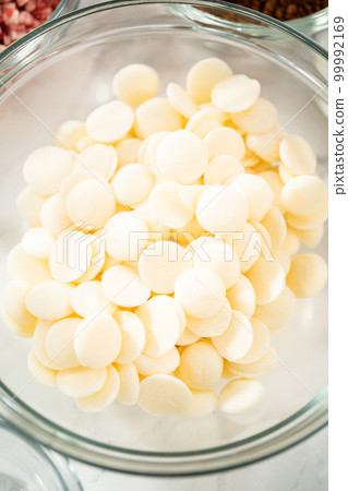 Measured ingredients in a glass mixing bowl to prepare peppermint white chocolate cookies. 99992169
