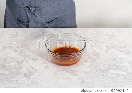 Mixing ingredients with a hand whisk to make a sweet glaze for meatloaf. Mixing ingredients with a hand whisk to make a sweet glaze for meatloaf. 99992343