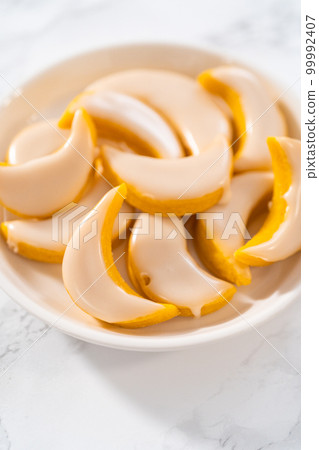 Lemon wedge cookies with lemon glaze. Freshly baked lemon wedge cookies with lemon glaze on a white plate. 99992407