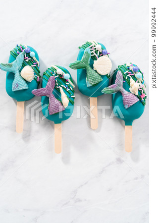 Mermaid cakesicles with drizzled chocolate, chocolate mermaid tails, seashells, and sprinkles. Mermaid cakesicles with drizzled chocolate, chocolate mermaid tails, seashells, and sprinkles. 99992444