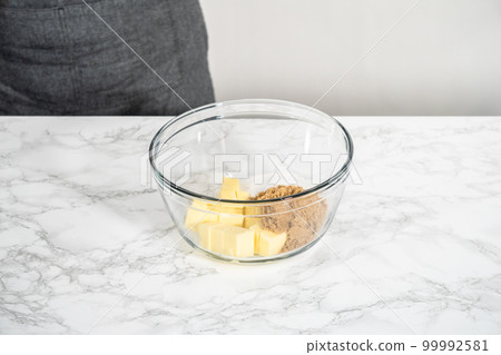 Mixing ingredients in a large glass mixing bowl to bake peppermint white chocolate cookies. 99992581