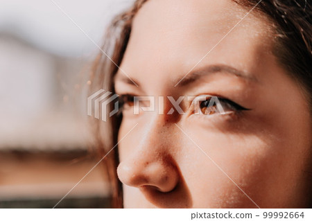 Women's eyes banner. Close up portrait of happy young caucasian woman with freckles at sunset time. Cute woman portrait. Women's eyes banner. Close up portrait of happy young caucasian woman with freckles at sunset time. Cute woman portrait. 99992664