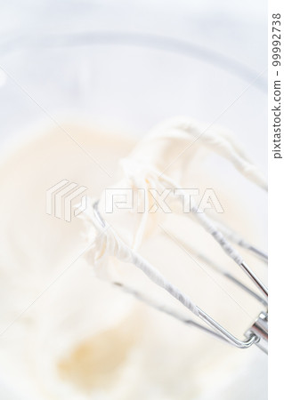 Preparing vanilla buttercream frosting for decorating funfettti bundt cake. Preparing vanilla buttercream frosting for decorating funfettti bundt cake. 99992738