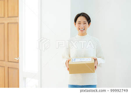 Woman holding cardboard at front door 99992749