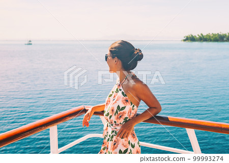 Cruise ship travel vacation woman looking at ocean from balcony of yacht deck. Luxury exotic tropical destination summer lifestyle Cruise ship travel vacation woman looking at ocean from balcony of yacht deck. Luxury exotic tropical destination summer lifestyle 99993274