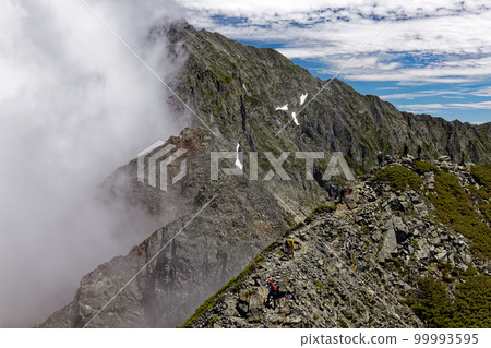 從北阿爾卑斯的西穗高岳冒出白雲的奧穗高岳的山脊線 從北阿爾卑斯的西穗高岳冒出白雲的奧穗高岳的山脊線 99993595