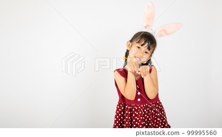 Happy Easter Day. Smile Asian little girl wearing bunny ears make hands act like a rabbit studio shotr isolated on white background with copy space, Easter eeasonal sale and discount 99995560