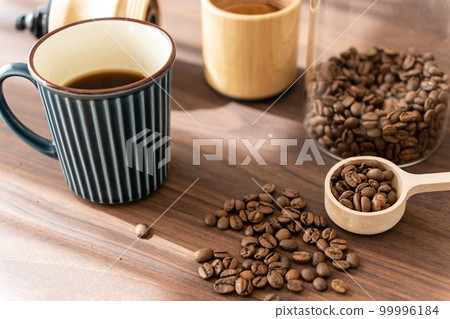 Hot coffee with coffee beans and coffee grinder 99996184