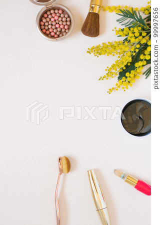Cosmetic concept. Decorative cosmetics and yellow mimosa flowers on a white background, top view, frame. Copy space and flat lay 99997656