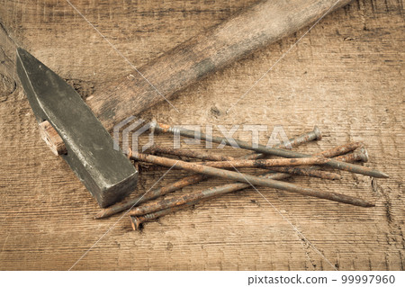 Vintage hammer with nails on wood background Vintage hammer with nails on wood background 99997960
