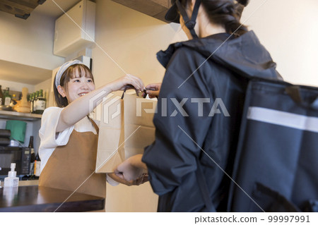 Restaurant clerk asking a delivery person for food delivery Restaurant clerk asking a delivery person for food delivery 99997991