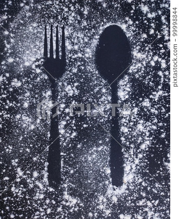 Fork and spoon image above flour, black background 99998844