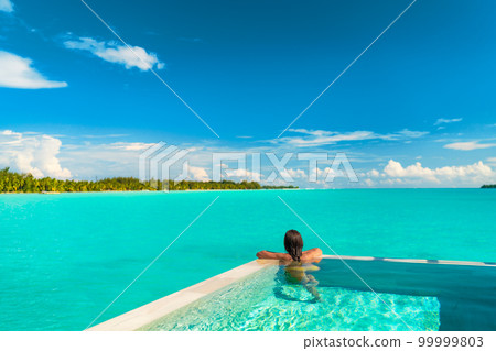 Luxury swimming pool spa resort travel honeymoon destination woman relaxing in infinity pool at hotel nature background summer holiday 99999803