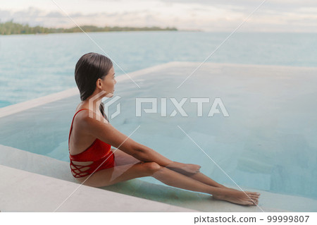 Spa wellness relaxation relaxing Asian woman in swimming pool looking at ocean view at dusk, well-being zen travel vacation at luxury resort overwater villa private room Spa wellness relaxation relaxing Asian woman in swimming pool looking at ocean view at dusk, well-being zen travel vacation at luxury resort overwater villa private room 99999807