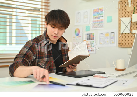 Young asian male designer planning mobile app development prototype wireframe design at creative office 100000025