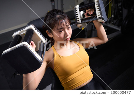 Young woman doing strength training at the gym 100000477