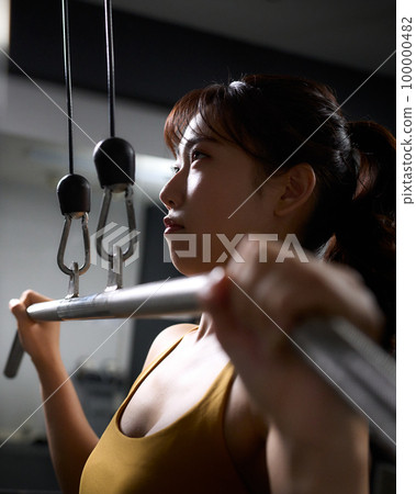 使用訓練機進行肌肉訓練的年輕女性 100000482