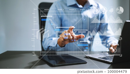 Businessman hand Project manager working and update tasks and Gantt chart scheduling virtual diagram.with smart phone, tablet and laptop in office.. 100004479