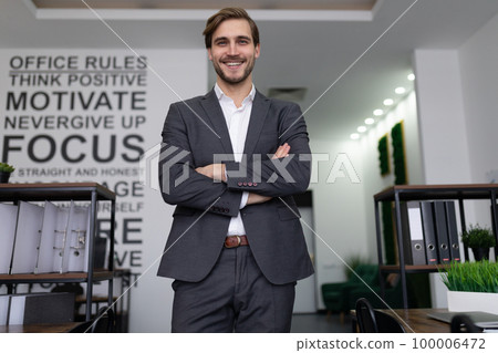 portrait of a successful male lawyer standing in an office building with arms crossed 100006472