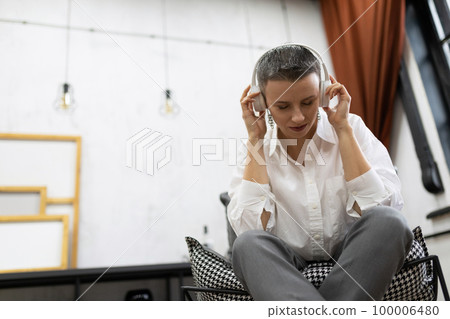 successful woman financier listens to music during a break and relaxes successful woman financier listens to music during a break and relaxes 100006480