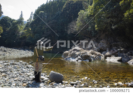 Man fly fishing in early spring river Man fly fishing in early spring river 100009271