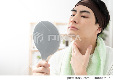 man checking his face in the mirror 100009526