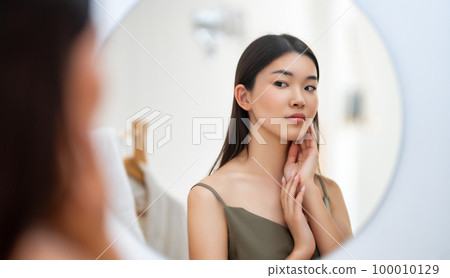 woman looking at mirror woman looking at mirror 100010129