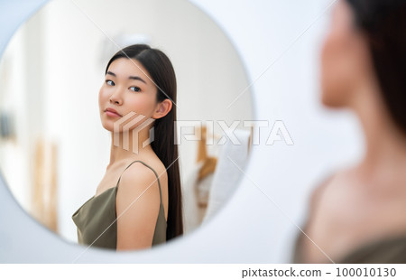 woman looking at mirror woman looking at mirror 100010130