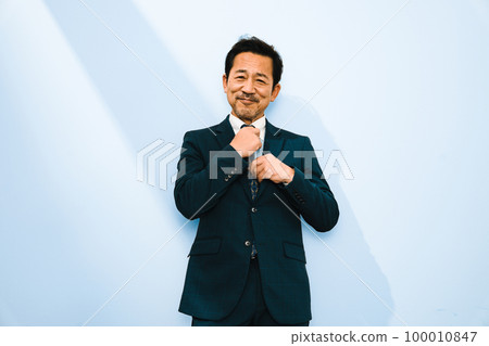 Portrait of a man in his 50s wearing a suit with a white background Portrait of a man in his 50s wearing a suit with a white background 100010847
