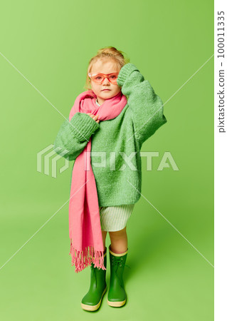 Happy smiling cute kid, little girl in fashionable look clothes and sunglasses posing over light green background. Spring fashion collection, happiness, ad concept Happy smiling cute kid, little girl in fashionable look clothes and sunglasses posing over light green background. Spring fashion collection, happiness, ad concept 100011335