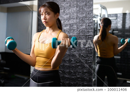 Young woman training with dumbbells Young woman training with dumbbells 100011406