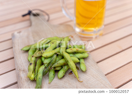 Edamame stir-fried with garlic and draft beer on a skillet Edamame stir-fried with garlic and draft beer on a skillet 100012057